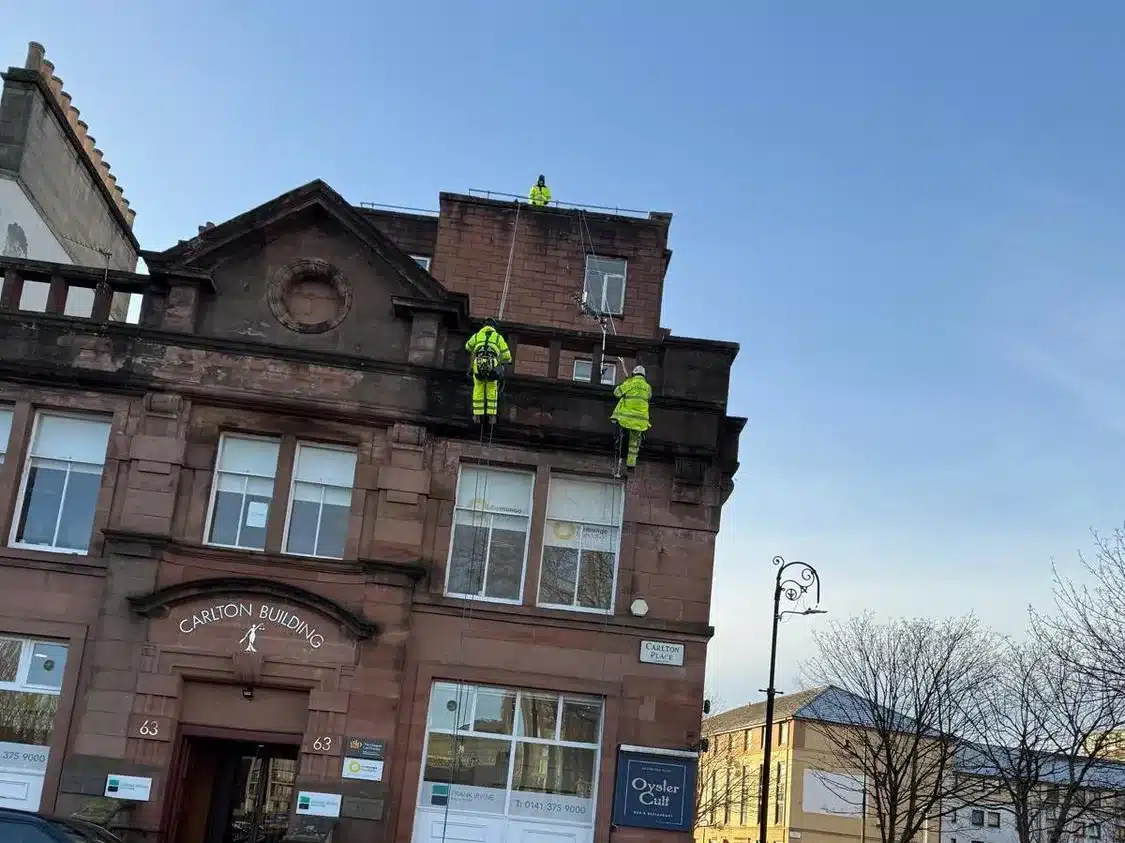 Technicians working on ropes on the front elevation at Carlton Place Glasgow
