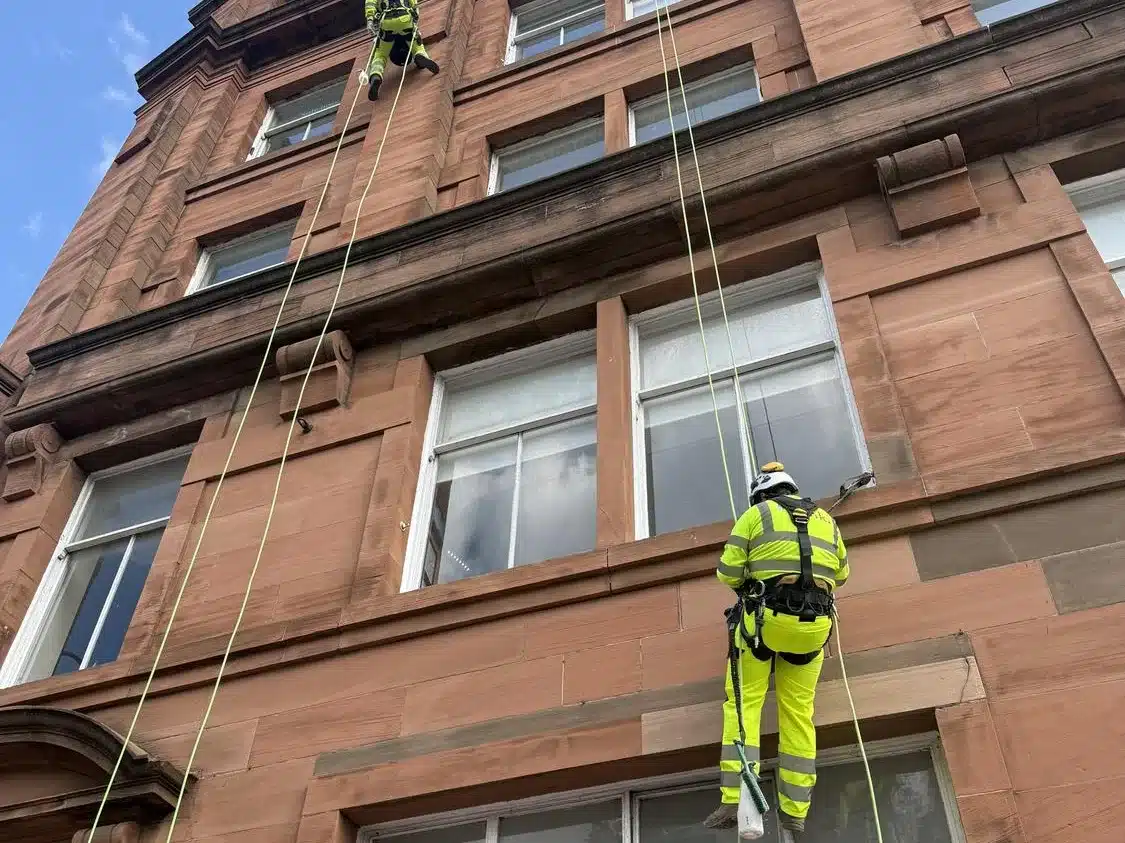 Rope access technician repointing the sandstone facade at Carlton Place Glasgow