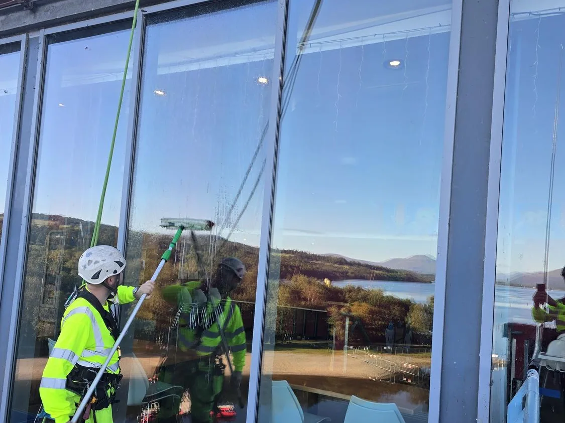 Technician cleaning aquarium glazing with views over Loch Lomond