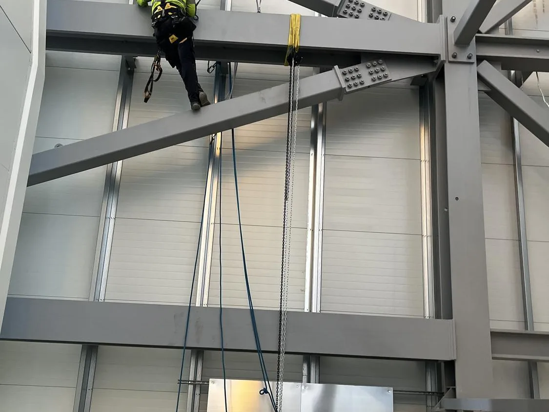 Rope access technician working on high level steelwork above the crane