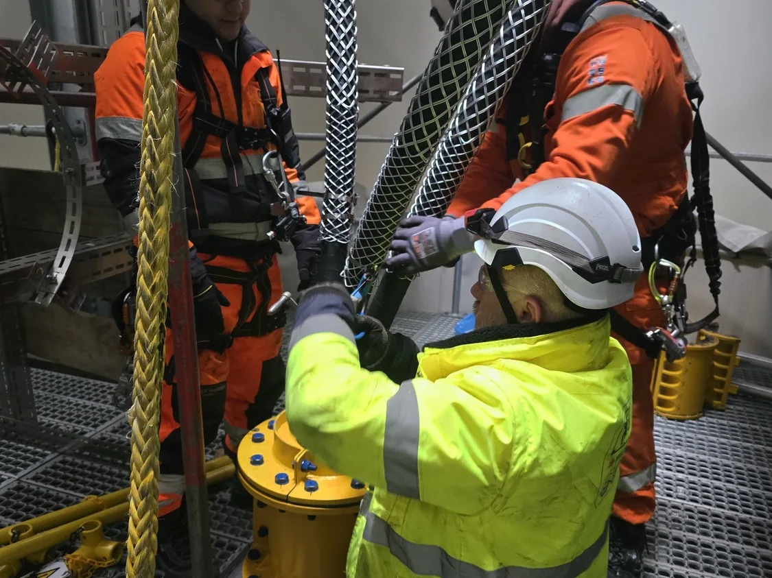 Rope access technicians rigging a subsea cable grip for pulling