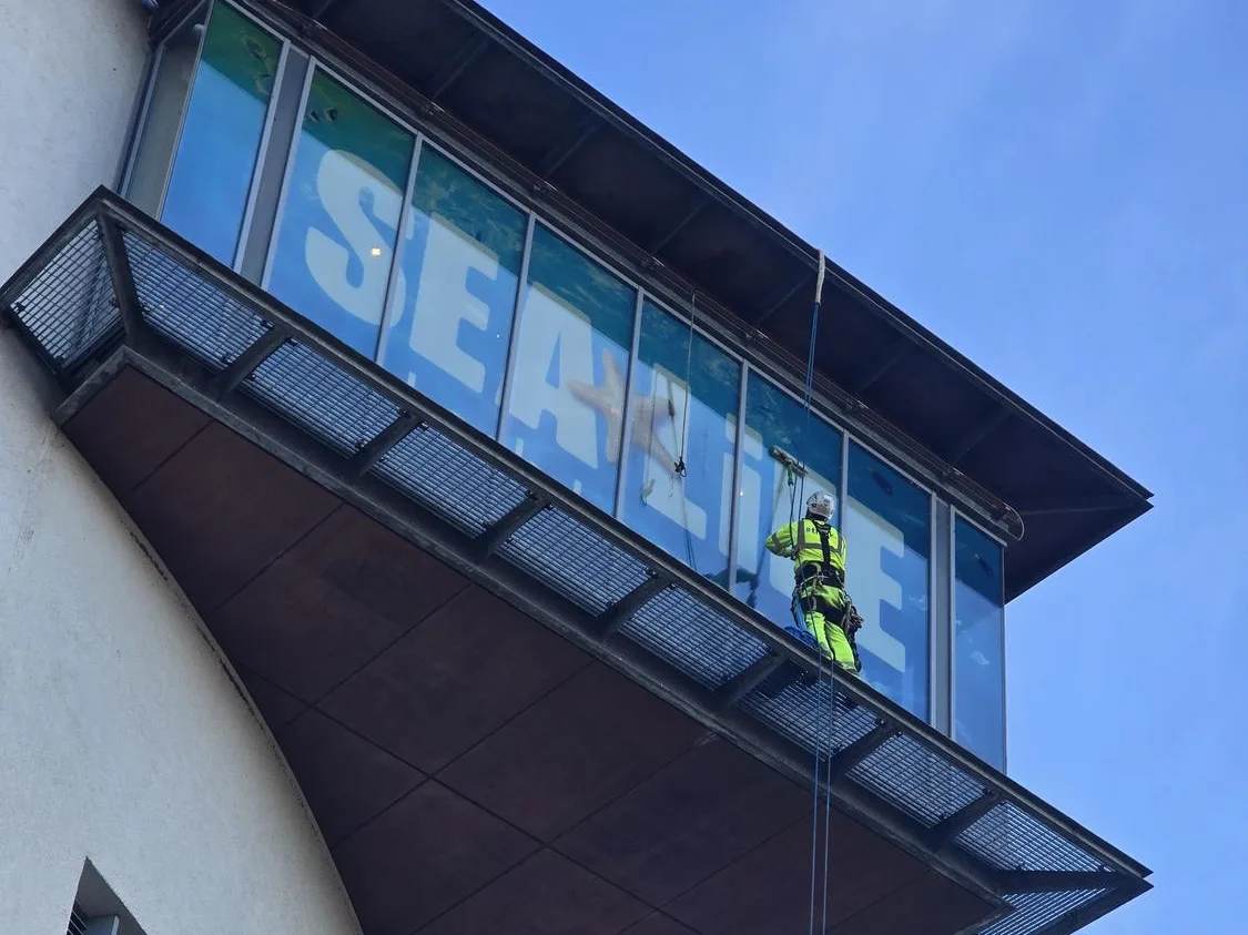 Rope access cleaning below the SEA LIFE signage overhang at Loch Lomond